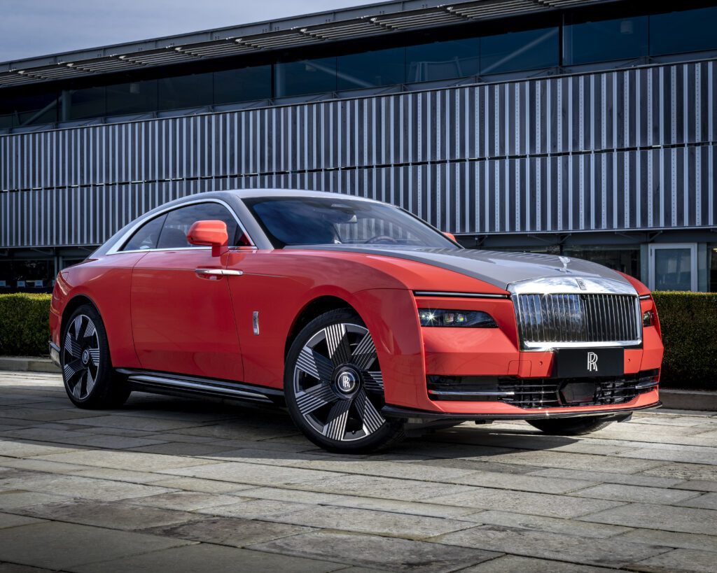 Rolls-Royce Spectre electric coupe in red with silver bonnet, front three-quarter view